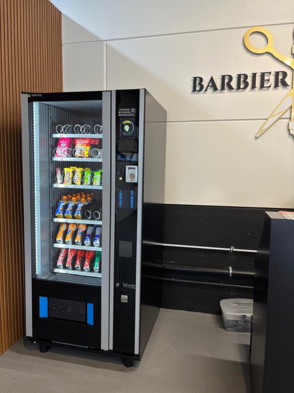 Vendingmachine in kapperszaak met snacks, drankjes en verzorgingsproducten, als extra service en 24/7 verkoopoplossing voor klanten tijdens en na hun bezoek
