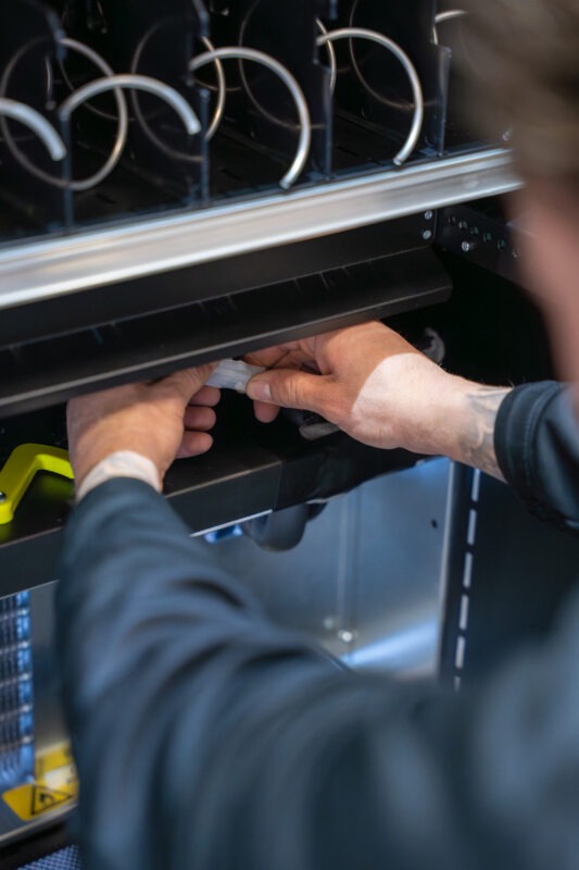 Monteur van Vending Master voert onderhoud en montagewerkzaamheden uit aan een vendingmachine op locatie