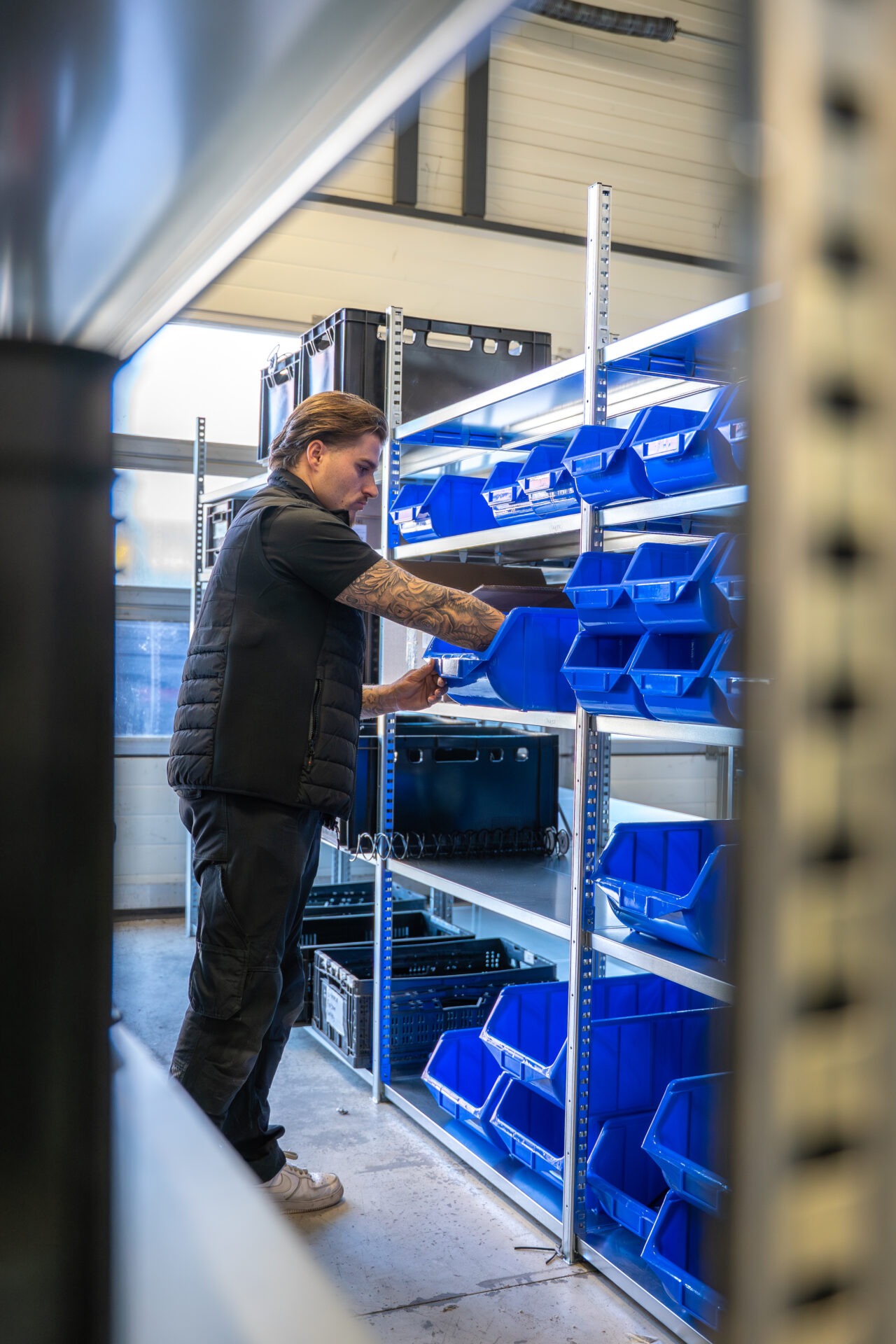 Monteur in magazijn die onderdelen selecteert en voorbereidt voor het gereedmaken van een vendingmachine voor levering en installatie