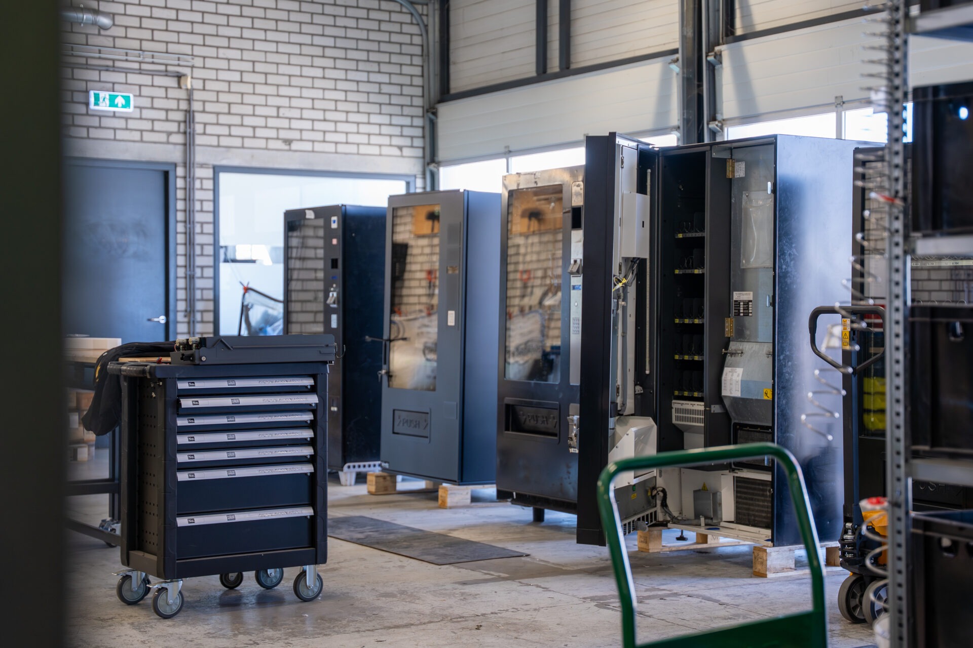 Werkplaats en magazijn van Vending Master met vendingmachines, onderdelen en gereedschap klaar voor assemblage, onderhoud en voorbereiding van automaten